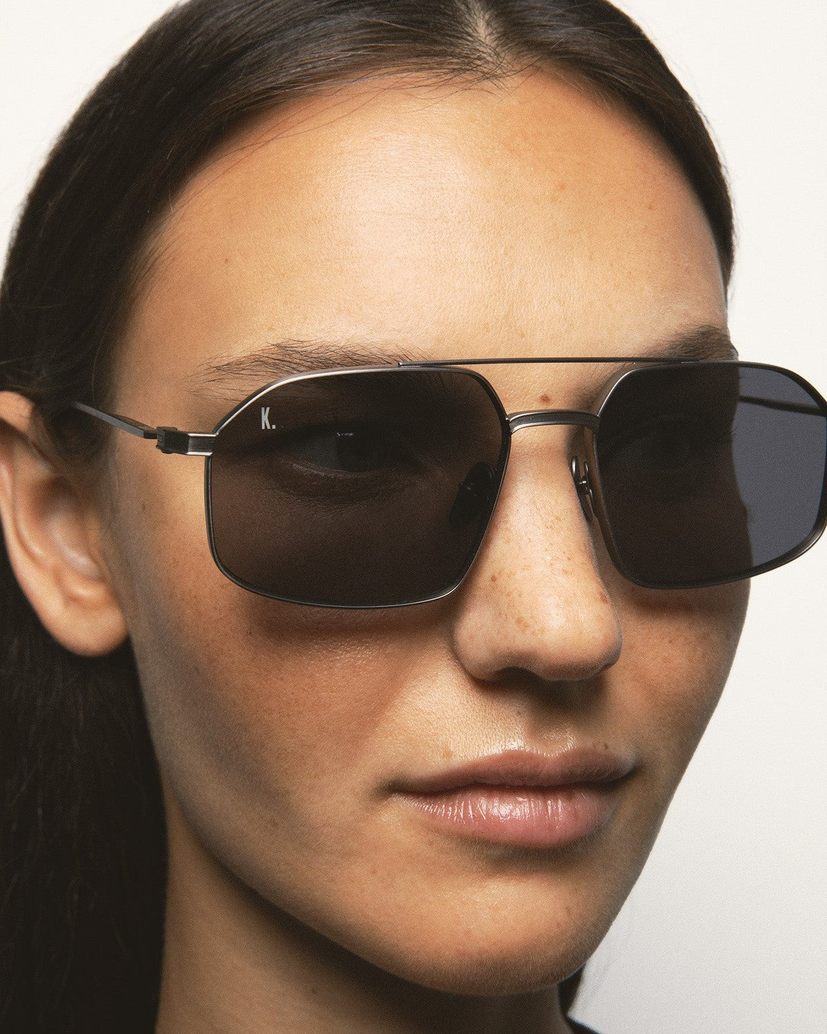 Angle view of KALEOS Ross Gun Matte Grey Mineral sunglasses on model.