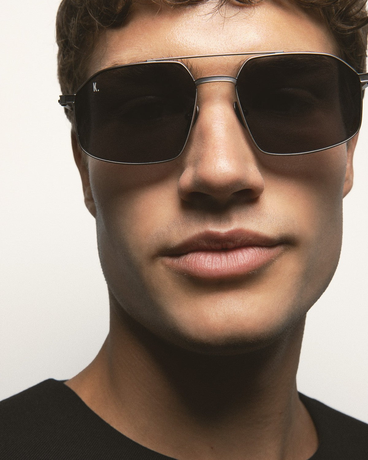 Close-up of model wearing KALEOS Ross Gun Matte Grey Mineral sunglasses.