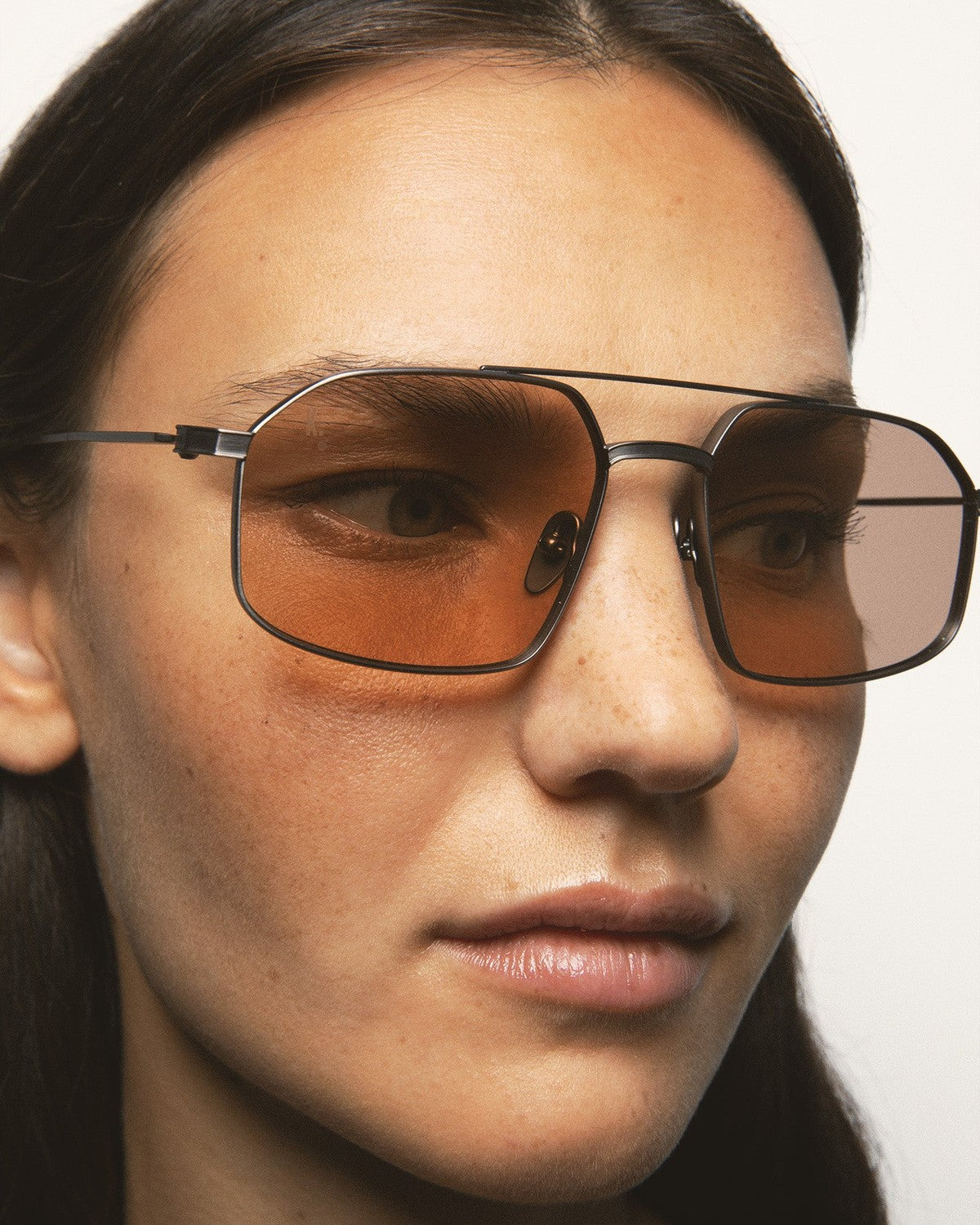 Close-up of model wearing KALEOS Ross Gun Matte Brown Photochromic sunglasses.