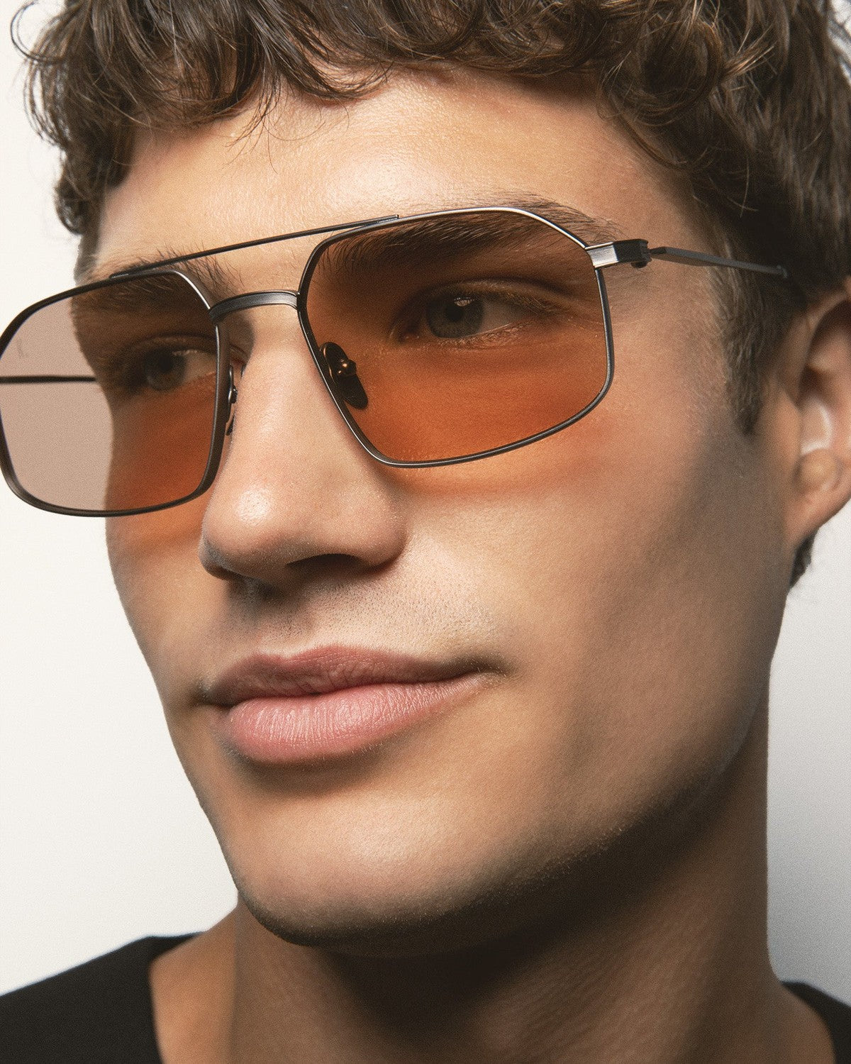 Angle view of model wearing KALEOS Ross Gun Matte Brown Photochromic sunglasses.