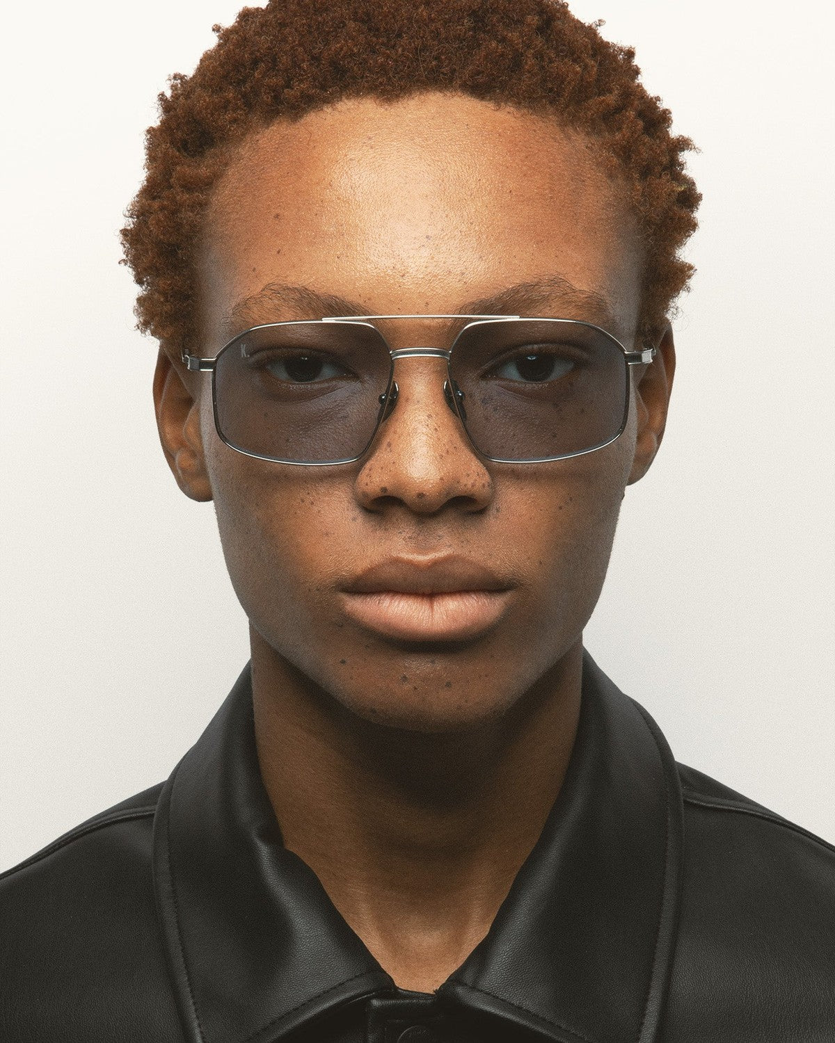 Model wearing KALEOS Ross Silver Blue Photochromic sunglasses, front view.