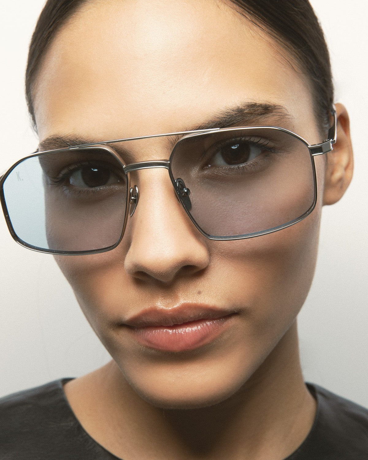Close-up of model wearing KALEOS Ross Silver Blue Photochromic sunglasses showing gradient lenses.