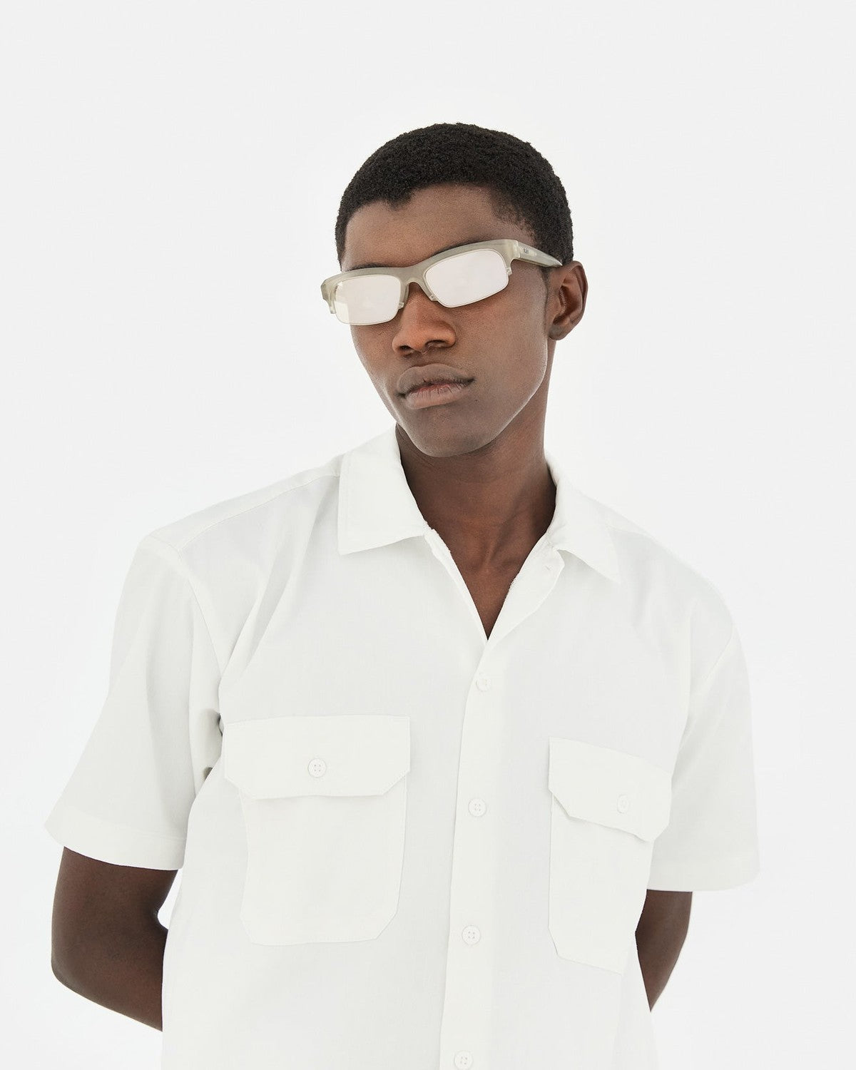 Model wearing RETROSUPERFUTURE Scatto Nebbia sunglasses with white short-sleeved shirt.