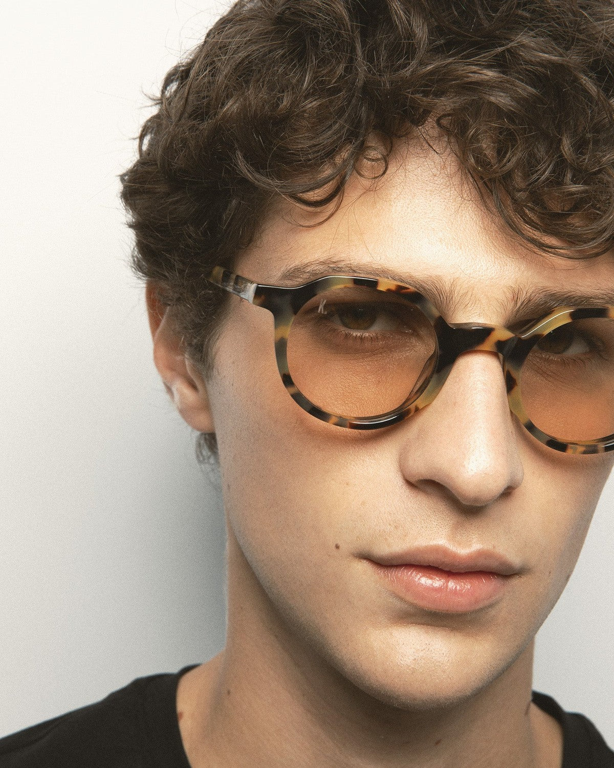 Angle view of model wearing KALEOS Scott Spotted Havana Brown Photochromic sunglasses.