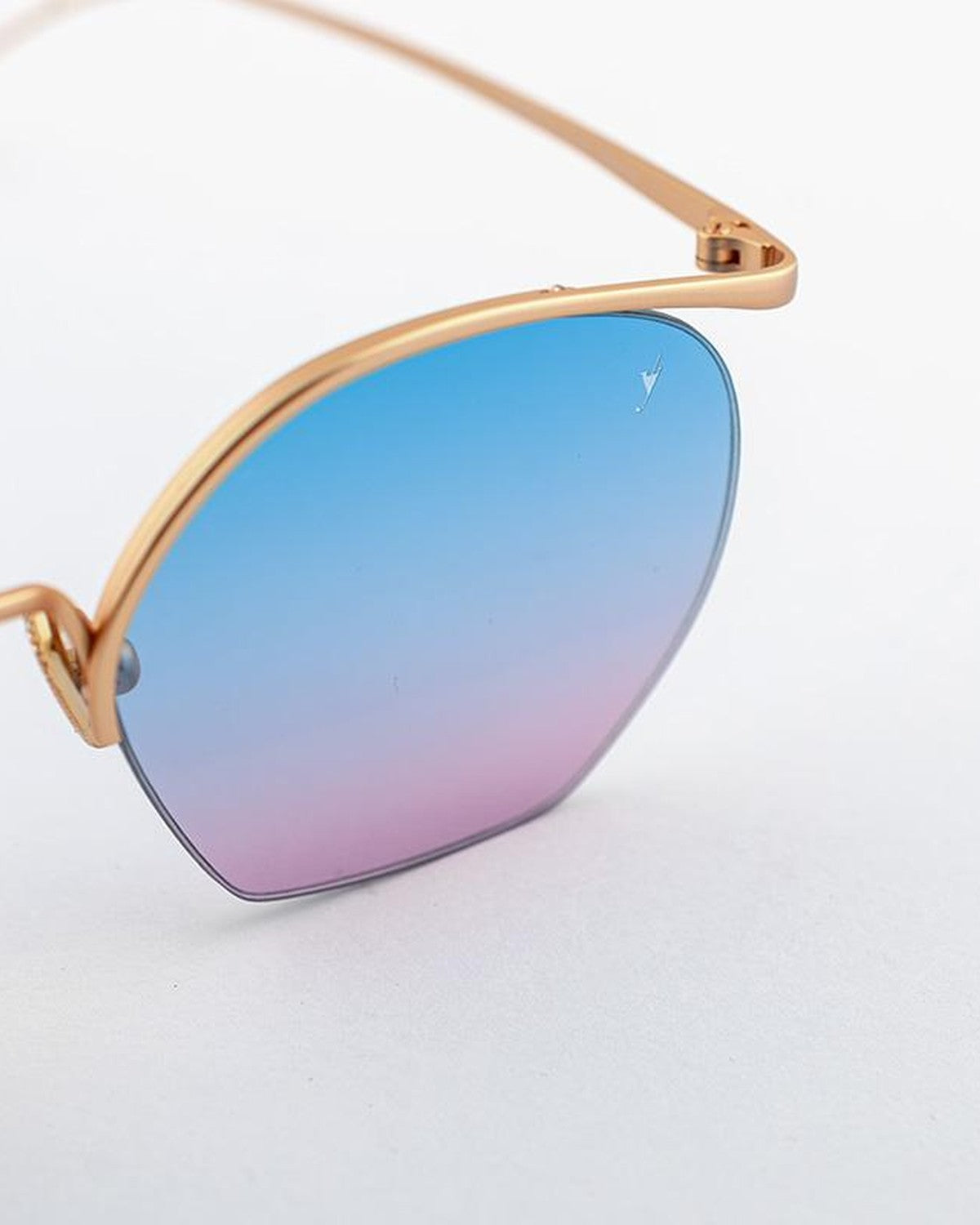 Close-up of the blue-to-pink gradient lens and gold metal temple of EYEPETIZER TIBERIO C.4-OP-42F sunglasses.