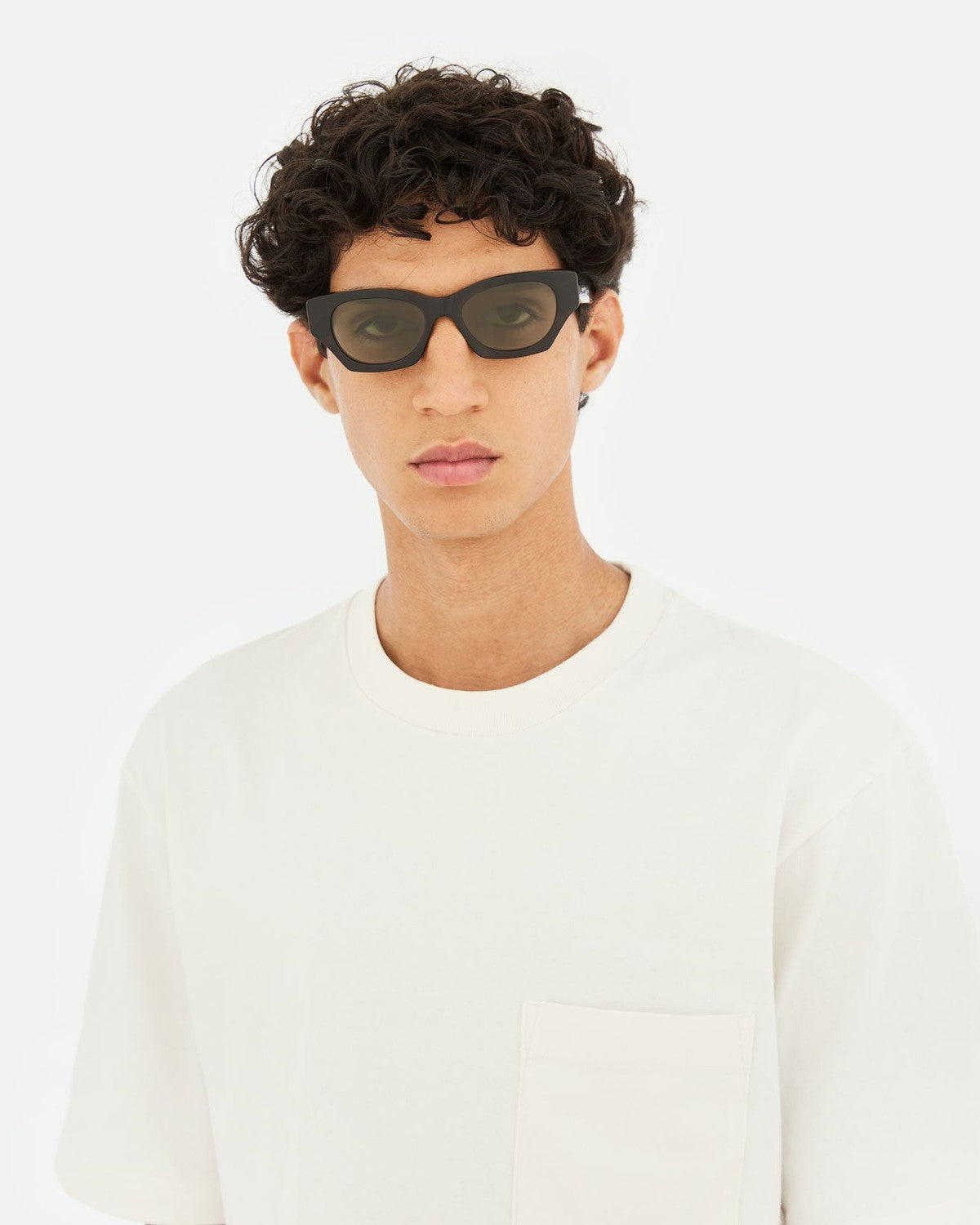 Model with dark curly hair wearing RETROSUPERFUTURE Tono 3627 sunglasses.