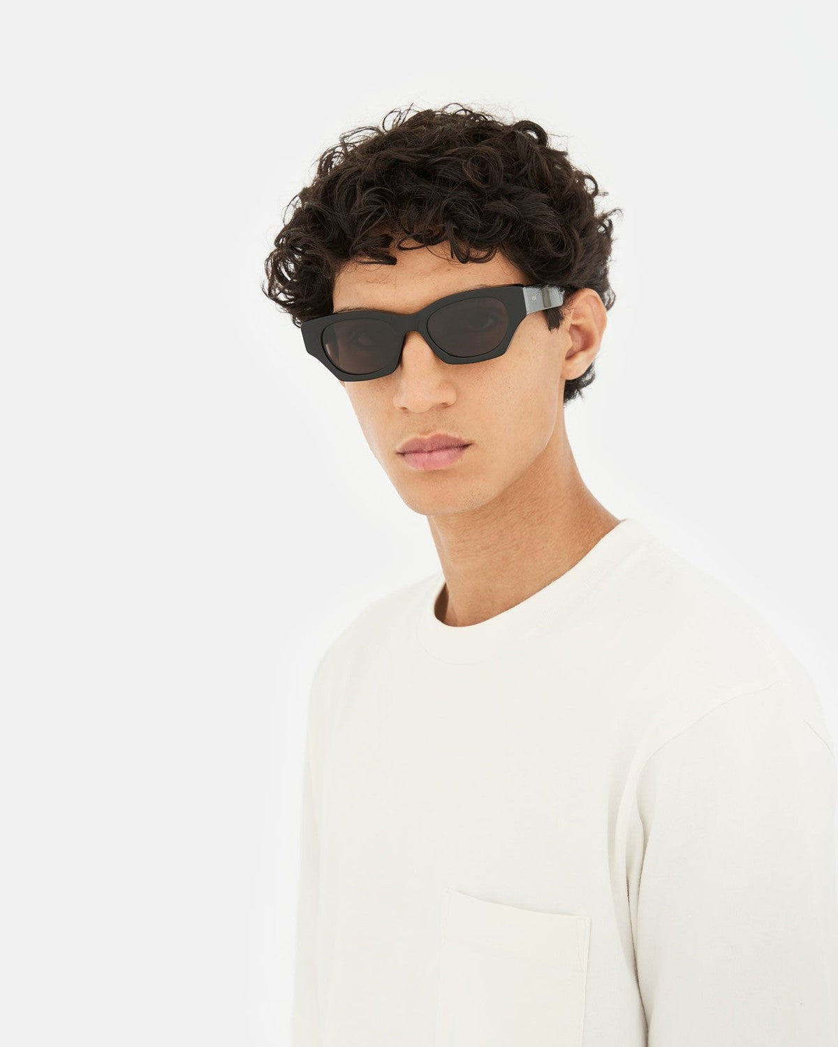 Model wearing RETROSUPERFUTURE Tono Black sunglasses in profile.