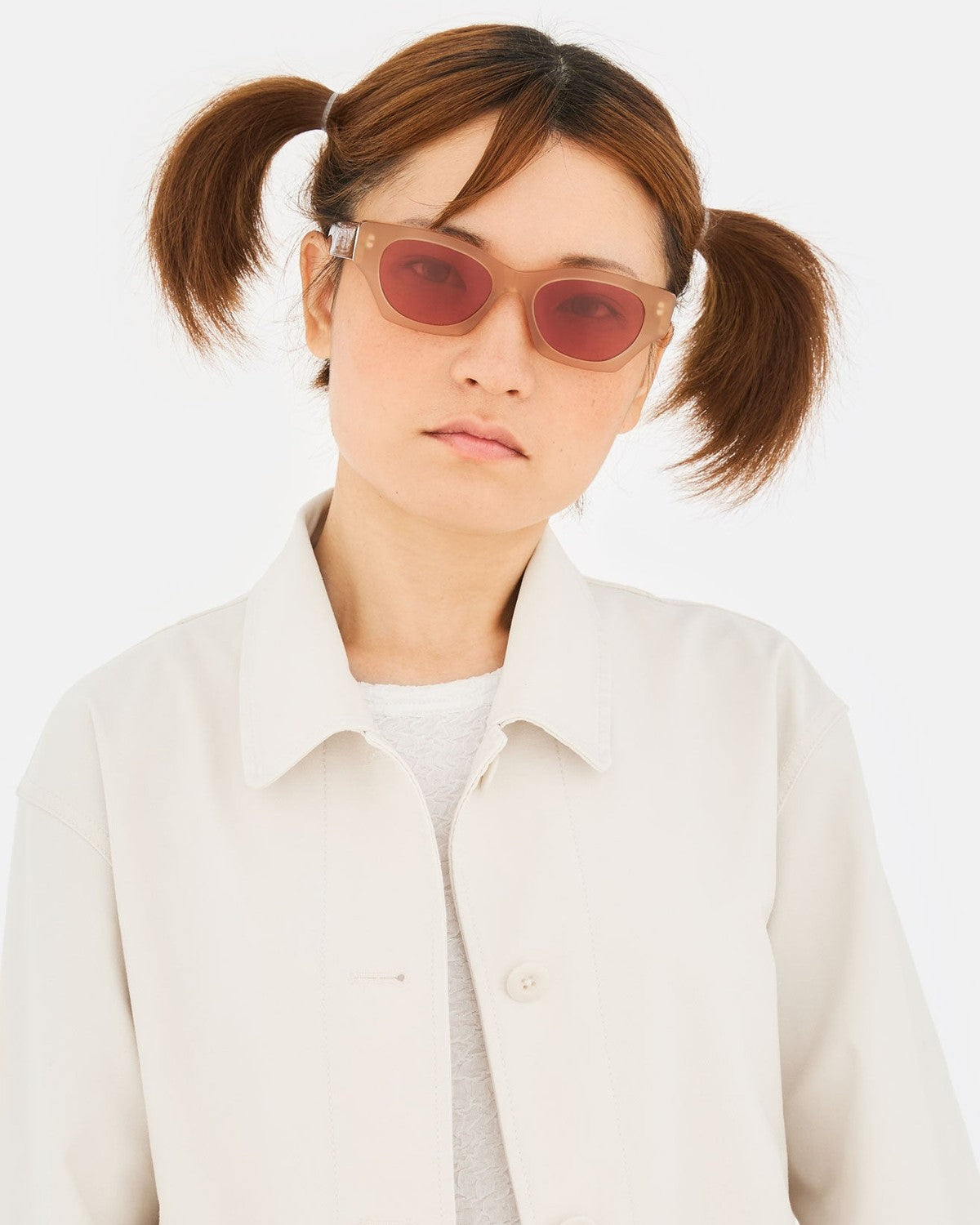 Model wearing RETROSUPERFUTURE Tono Light Brown sunglasses with hair in two ponytails.