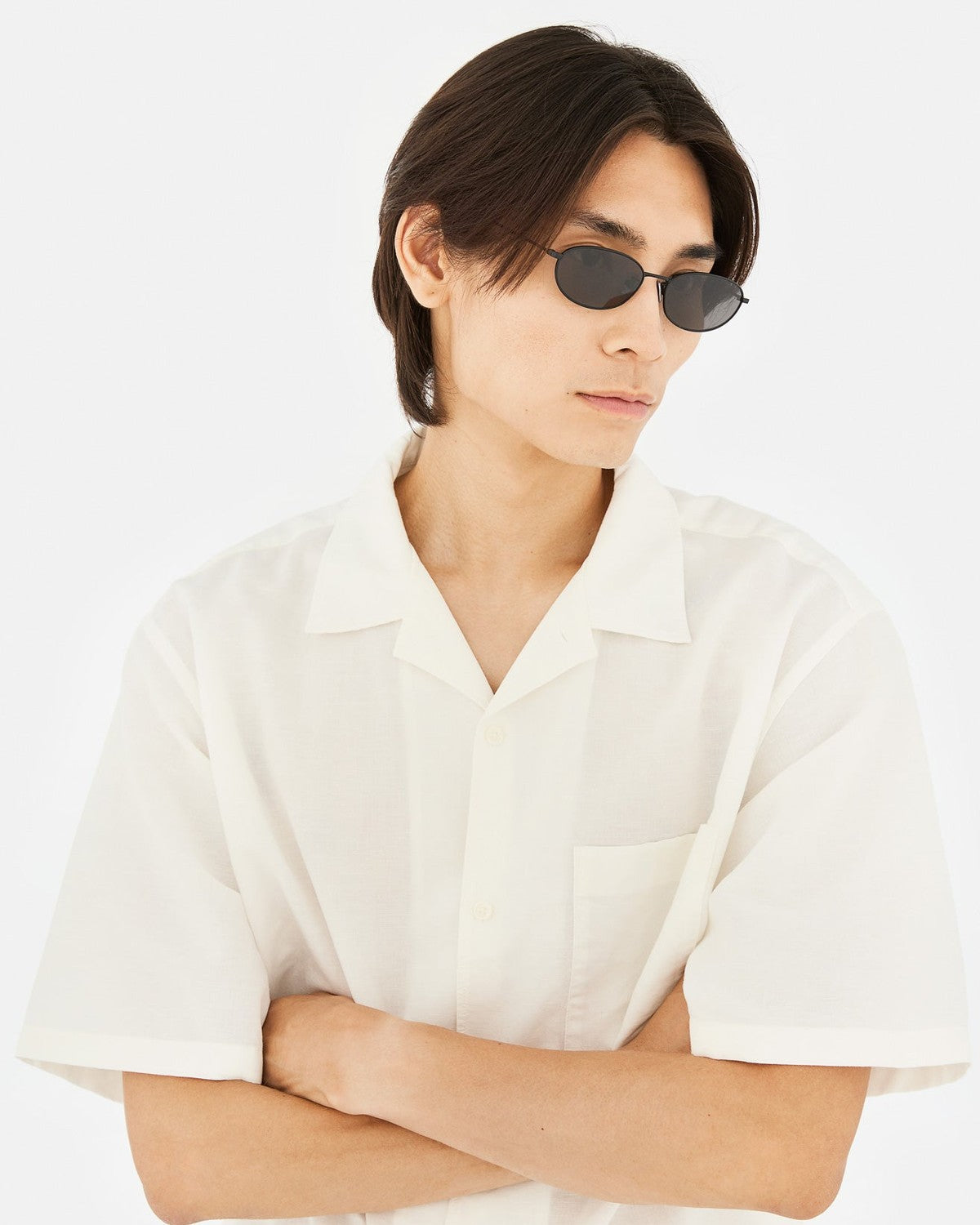Model wearing RETROSUPERFUTURE Uovo Nero sunglasses with white short-sleeve shirt.
