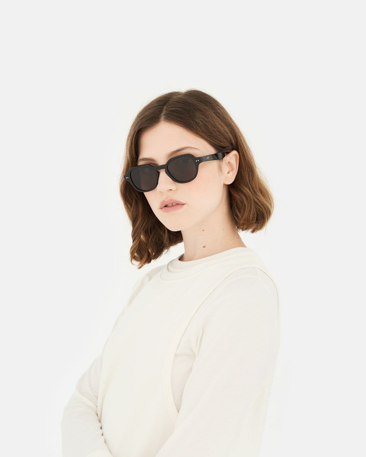 Model wearing RETROSUPERFUTURE Voce Black sunglasses in angled profile.