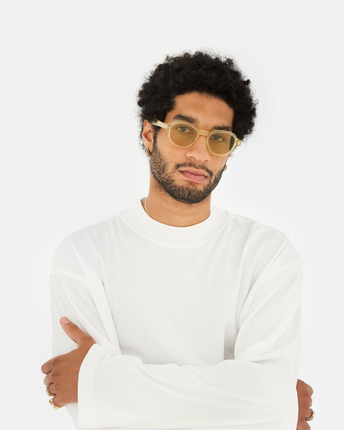 Model wearing RETROSUPERFUTURE Voce Cream sunglasses with arms crossed.