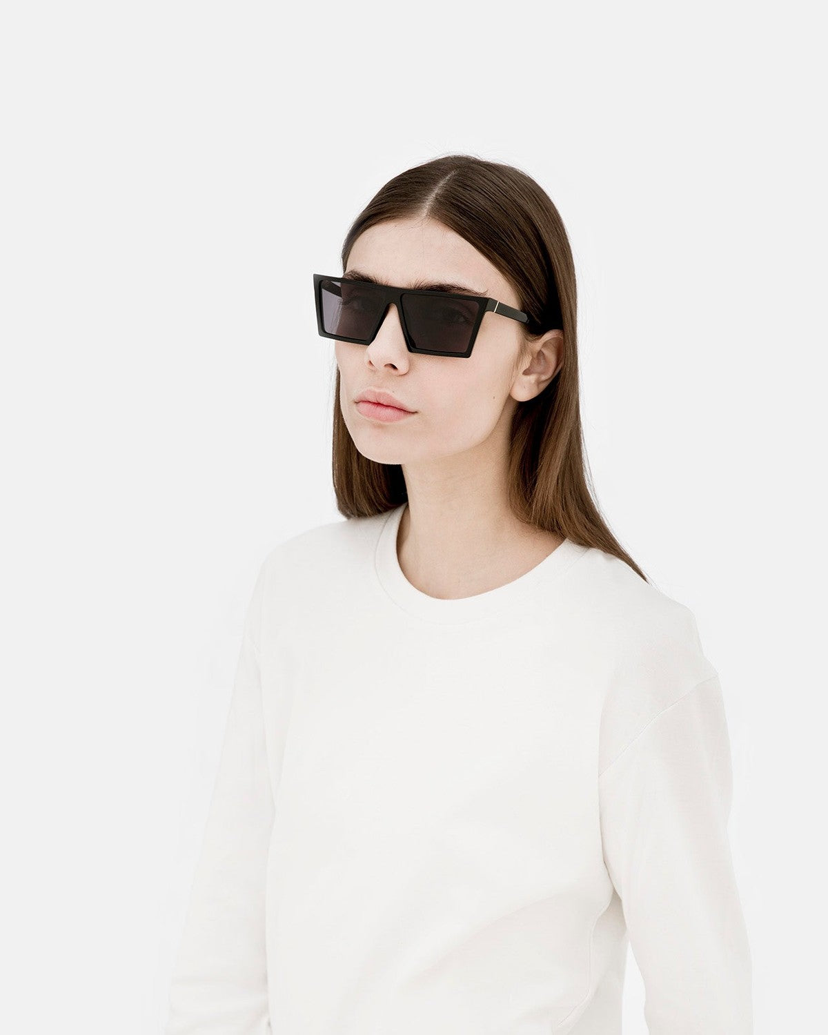 Model wearing RETROSUPERFUTURE W Black sunglasses with a white top.