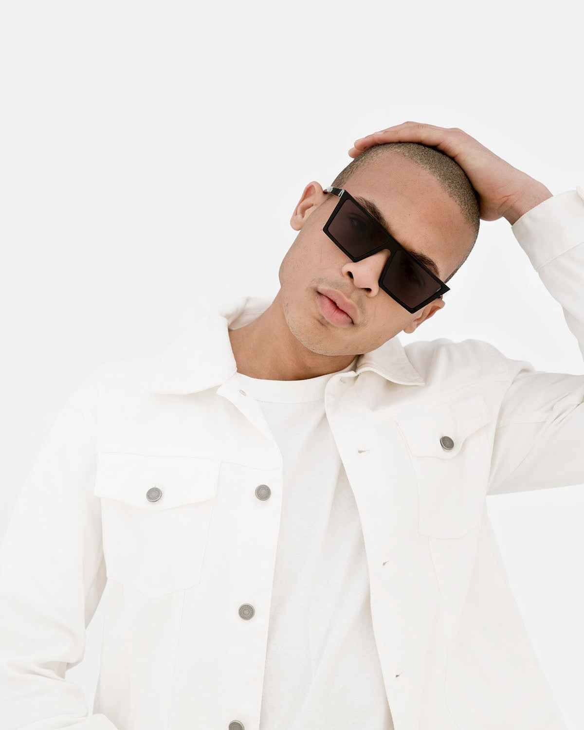 Model wearing RETROSUPERFUTURE W Black sunglasses with a white jacket.