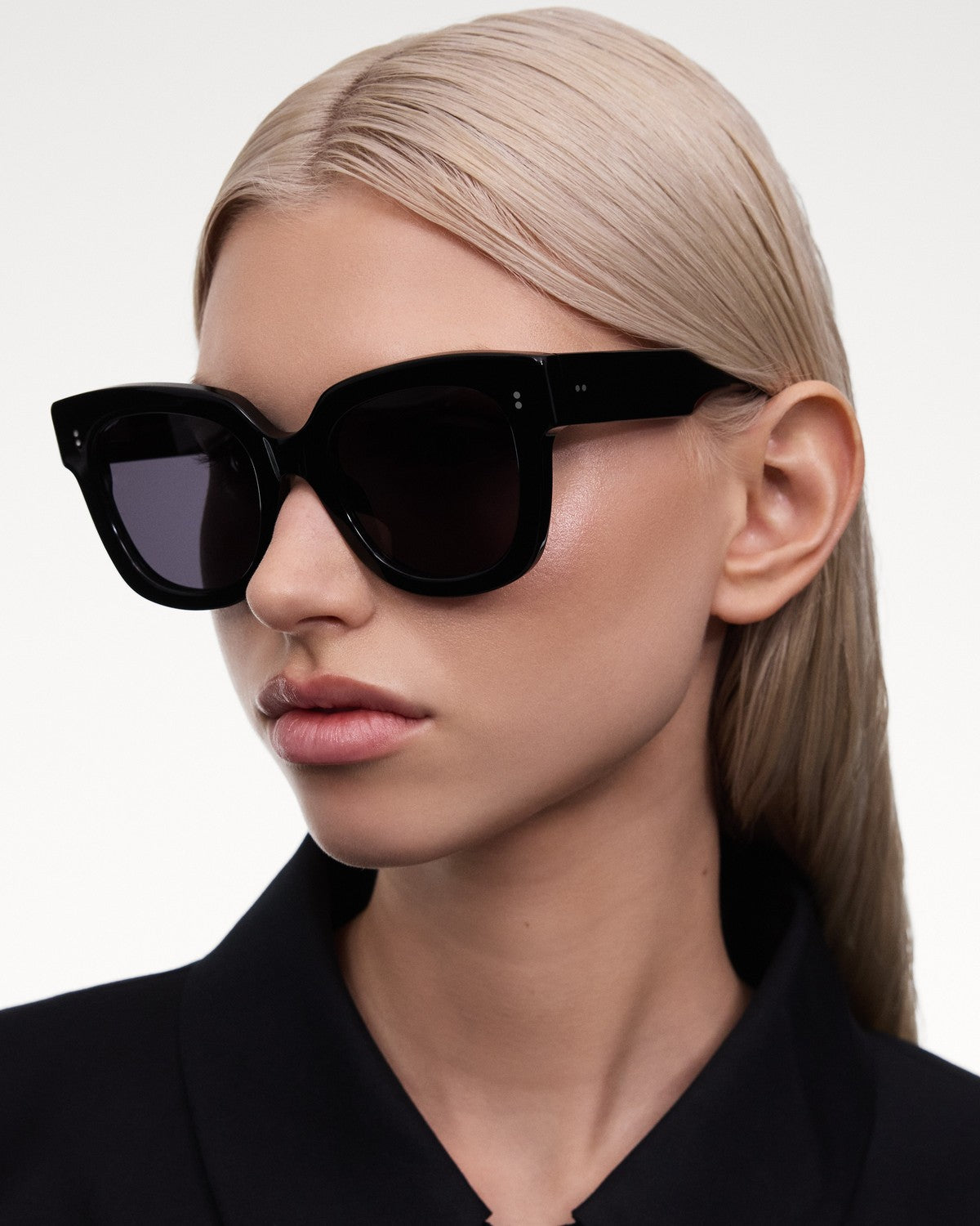 Model wearing CHIMI X14 Black Black sunglasses in angled profile.