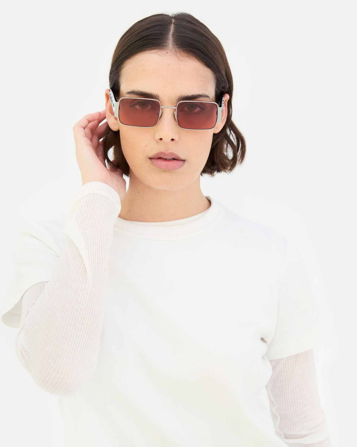 Model wearing RETROSUPERFUTURE Z Bordeaux sunglasses in front view with hand to temple.