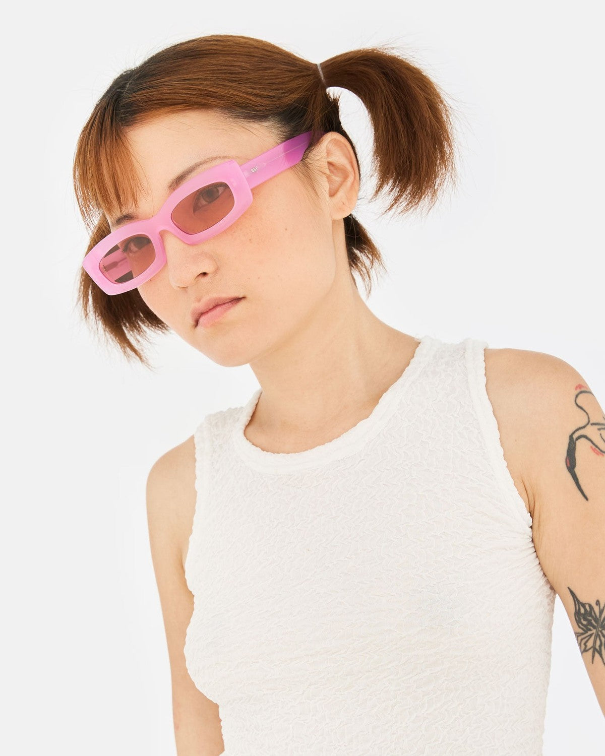 Model wearing RETROSUPERFUTURE Zaga Pink sunglasses, angled pose.